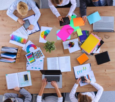 İş adamları iş toplantısında, ofiste oturup tartışıyorlar.