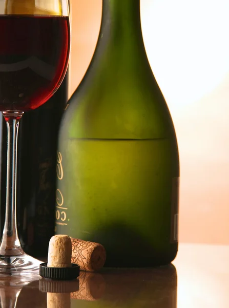 Elegancki kieliszek do wina i butelka wina w ciemnym tle — Zdjęcie stockowe