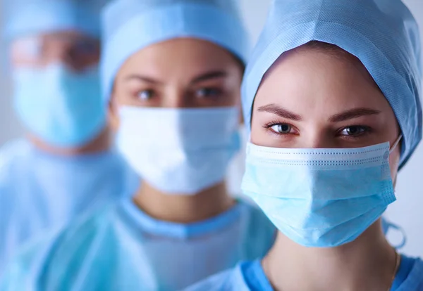 Chirurgen team, dragen beschermende uniformen, petten en maskers — Stockfoto