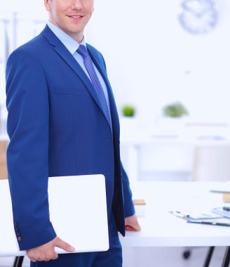 Ofiste masasının karşısında duran bir iş adamı ya da yönetici.