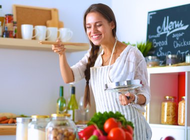 Mutfakta ahşap kaşıkla yemek pişiren kadın