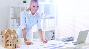 Ofisinde planları olan kadın mimarın portresi.