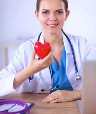 Masada oturan kırmızı kalp sembollü genç doktor.