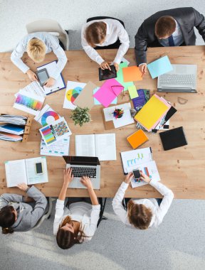 İş adamları iş toplantısında, ofiste oturup tartışıyorlar.