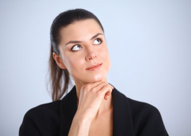 ayakta, gri arka plan üzerinde izole genç kadın