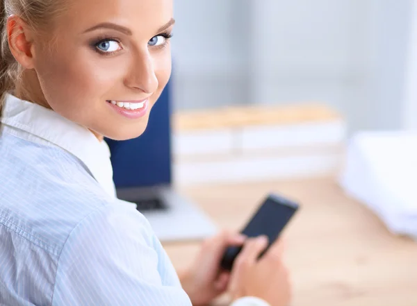Femme d'affaires envoyer un message avec smartphone assis dans le bureau — Photo