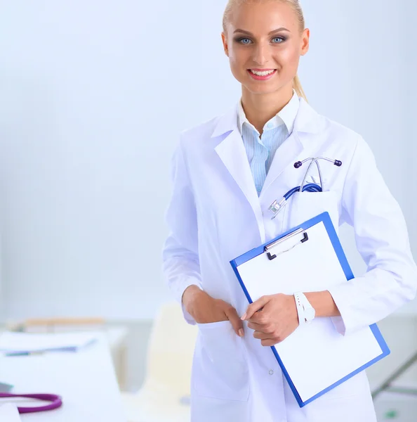 Attraktive junge Geschäftsfrau steht mit Ordner am Schreibtisch im Büro — Stockfoto