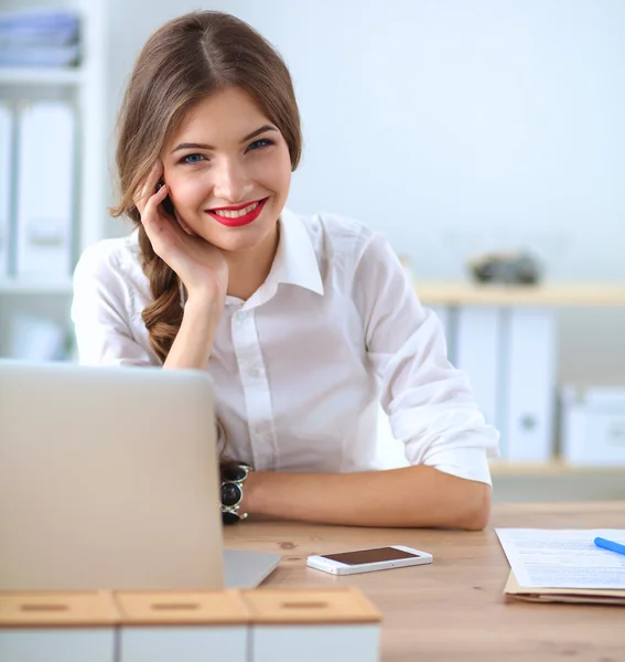 Attraktive Geschäftsfrau sitzt auf Schreibtisch im Büro — Stockfoto
