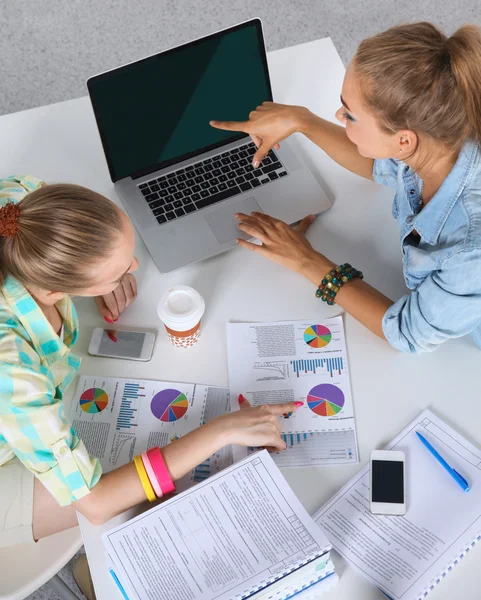 Dos mujeres trabajando juntas en la oficina, sentadas en el escritorio — Foto de Stock