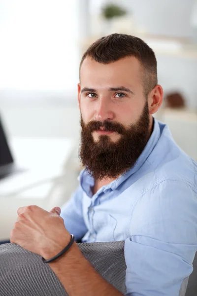 Jonge zakenman zit op stoel in functie — Stockfoto