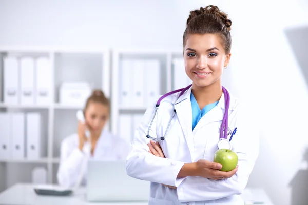 Kvinna läkare hand håller ett grönt äpple — Stockfoto