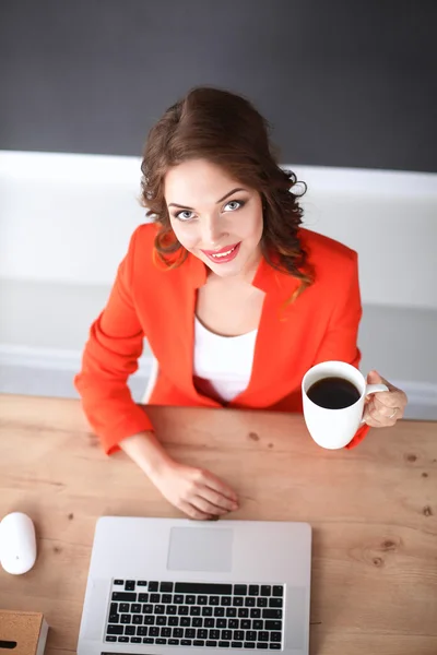 Attraktive Frau sitzt im Büro am Schreibtisch und arbeitet mit Laptop — Stockfoto