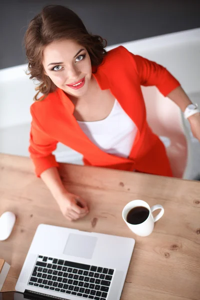 Attraktive Frau sitzt im Büro am Schreibtisch und arbeitet mit Laptop — Stockfoto