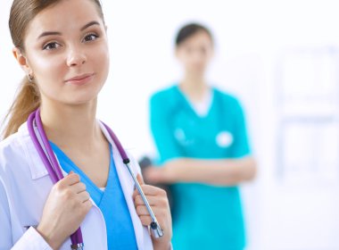 Kadın doktor hastanede dosyayla bekliyor.