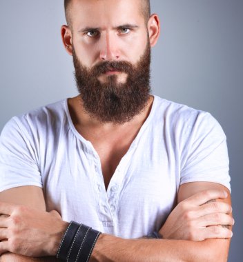 Ayakta, gri arka plan üzerinde izole yakışıklı adam portresi