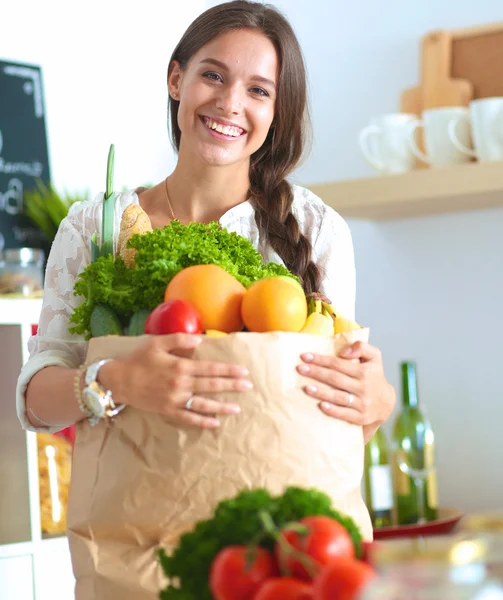 Young woman holding grocery shopping bag with vegetables — Stock Photo, Image