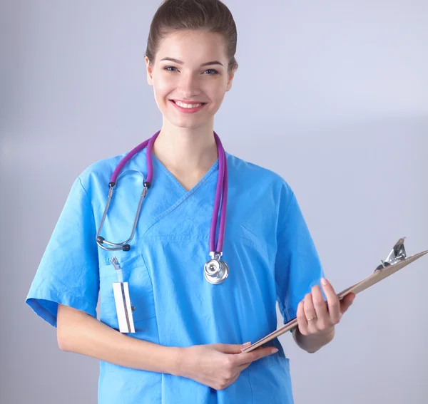 Médecin souriante avec un dossier en uniforme debout à l'hôpital — Photo