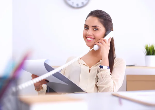 Jeune femme d'affaires assise au bureau et parlant au téléphone — Photo