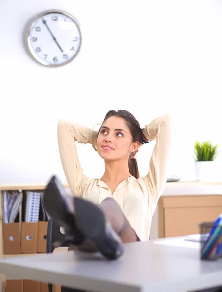 Zakelijke vrouw ontspannen met handen achter haar hoofd en zitten op een bureaustoel — Stockfoto