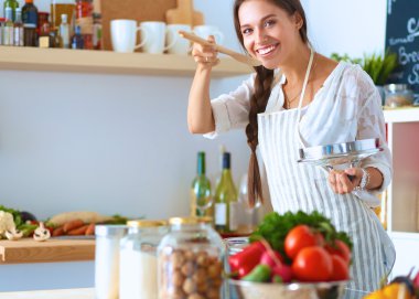Mutfakta ahşap kaşıkla yemek pişiren kadın