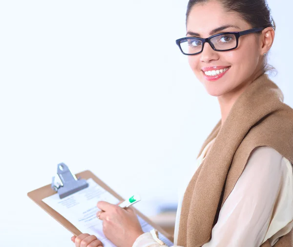Attraktiv ung affärskvinna står nära skrivbord med mapp på kontoret — Stockfoto