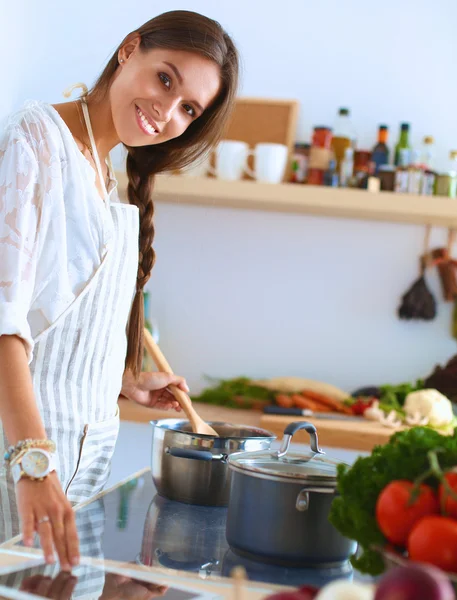 Mutfakta ahşap kaşıkla yemek pişiren kadın — Stok fotoğraf