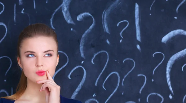 Young girl with question mark on a gray background — Stock Photo, Image