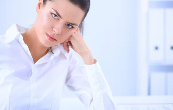 Attractive businesswoman sitting on a desk with laptop in the office — Stock Photo, Image