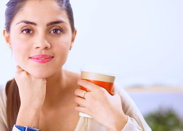 Schöne Geschäftsfrau genießt Kaffee im hellen Büro — Stockfoto