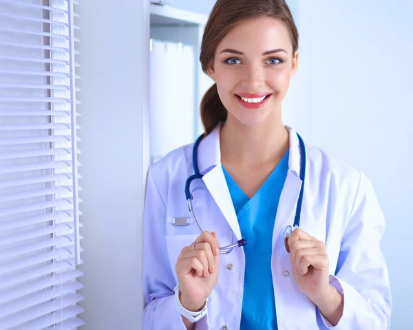 Portrait of young woman doctor with white coat standing in hospital — Stock Photo, Image