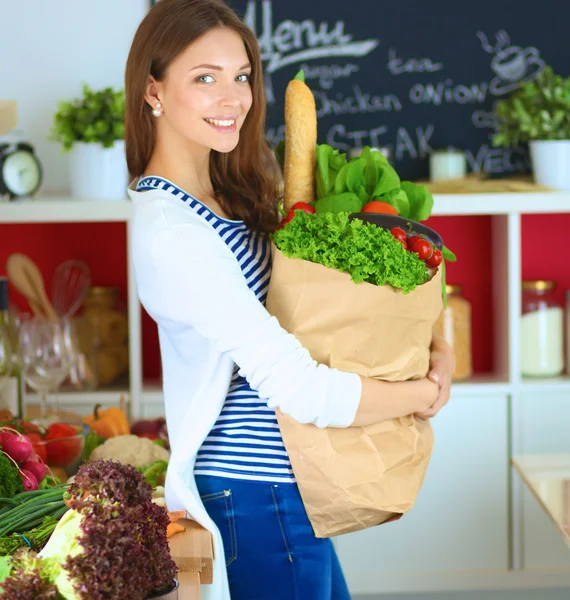 Young woman holding grocery shopping bag with vegetables — Stock Photo, Image