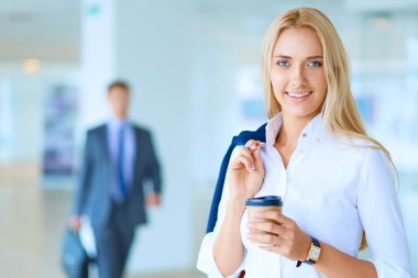 Yound kadın ayakta ofisindeki kahve içmek