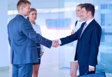 İki başarılı iş adamının el sıkışırken tam boy görüntüsü.