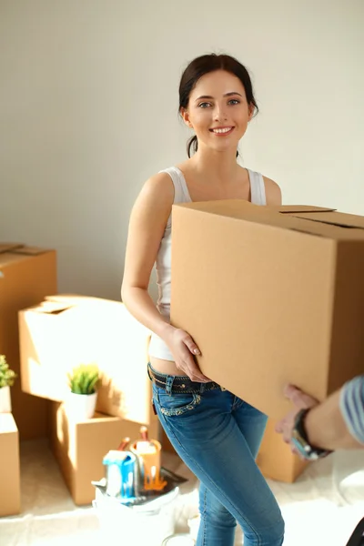Feliz pareja joven desempacar o empacar cajas y mudarse a un nuevo hogar — Foto de Stock