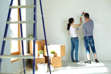 Mutlu gülümseyen genç çift boya iç cephe yeni evin portresi