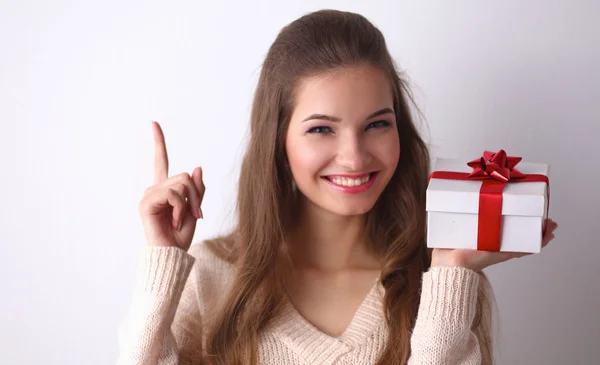 Młoda kobieta szczęśliwy uśmiech trzymać pudełko w ręce, stojąc na szarym tle — Zdjęcie stockowe