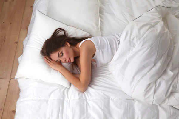 Beautiful girl sleeps in the bedroom, lying on bed — Stock Photo, Image