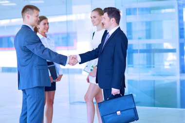 İki başarılı iş adamının el sıkışırken tam boy görüntüsü.