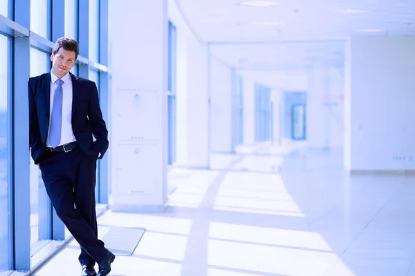 Retrato del hombre de negocios de pie cerca de la ventana en la oficina — Foto de Stock