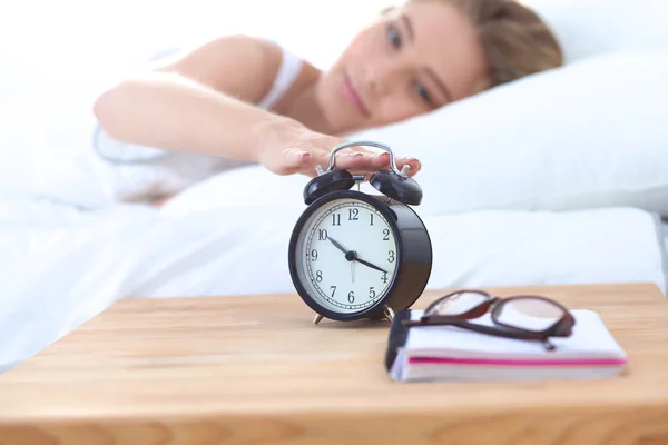 Jonge slapende vrouw en wekker in slaapkamer thuis — Stockfoto