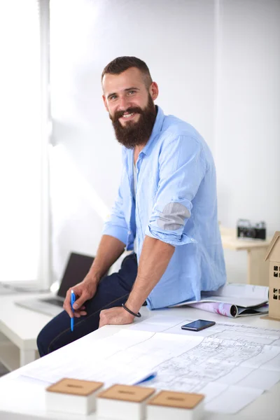 Retrato de diseñador masculino en sombrero con planos en el escritorio —  Fotos de Stock