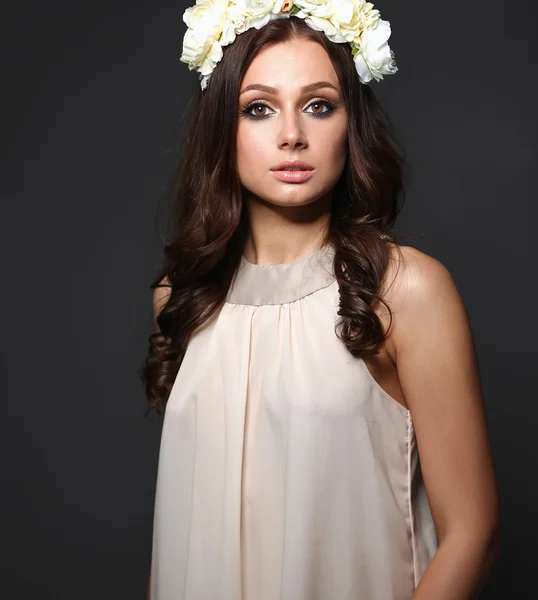 Retrato de una hermosa mujer con flores en el pelo. Moda — Foto de Stock