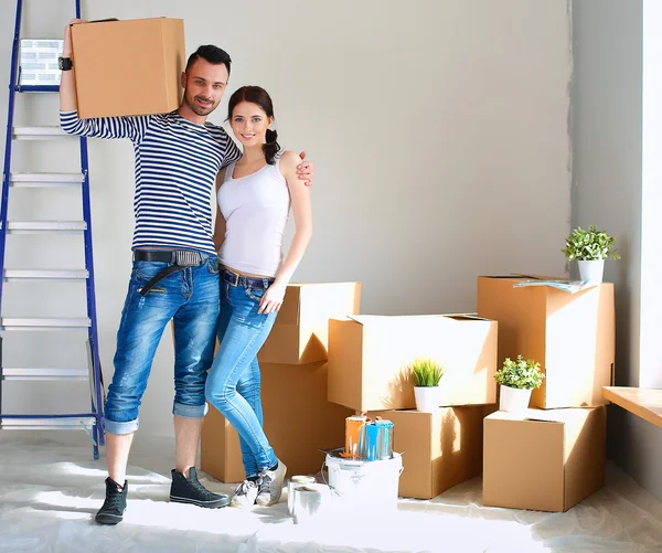 Glückliches junges Paar packt Kisten aus und zieht in ein neues Zuhause — Stockfoto