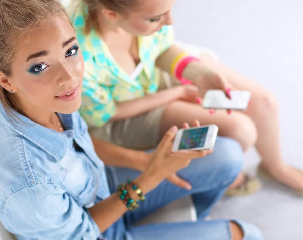 Twee meisjes kijken op de telefoon foto samen — Stockfoto