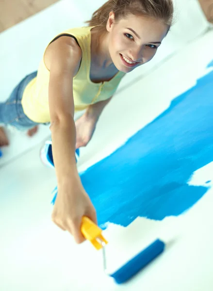 Güzel genç bir kadın duvar boyuyor. — Stok fotoğraf