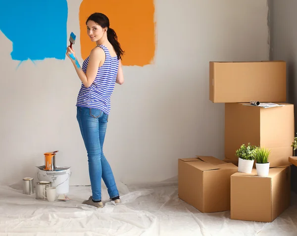 Happy smiling woman painting interior wall of new house — Stock Photo, Image