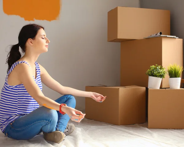 Woman in a new home with cardboard boxes — Stock Photo, Image