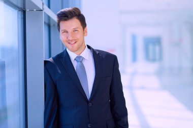 Ofisteki pencerenin yanında duran işadamının portresi