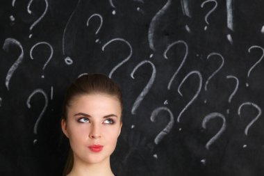 soru işareti gri bir arka plan üzerinde bulunan genç kız