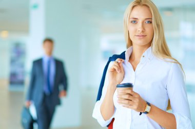 Yound kadın ayakta ofisindeki kahve içmek